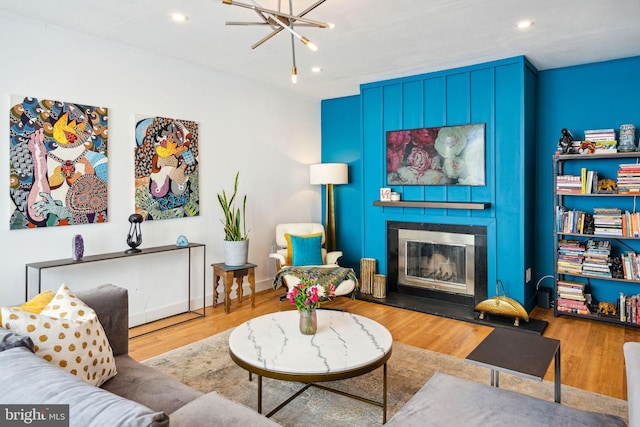 living room featuring a notable chandelier, light hardwood / wood-style flooring, and a fireplace