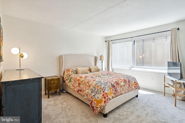 bedroom featuring a textured ceiling and light carpet