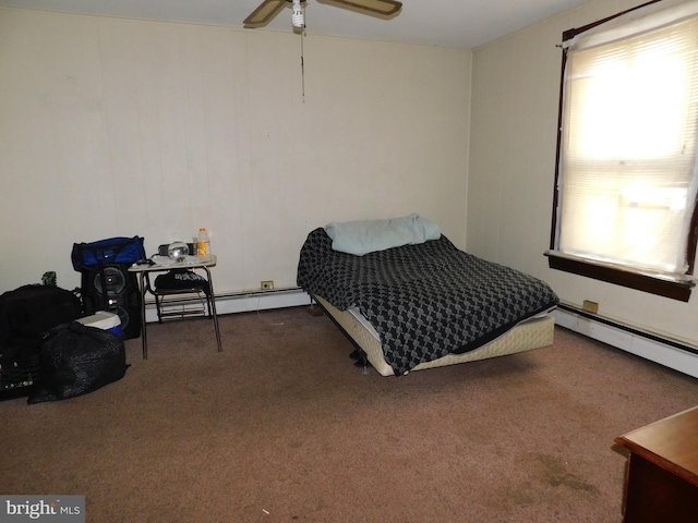 bedroom with dark carpet, multiple windows, baseboard heating, and ceiling fan