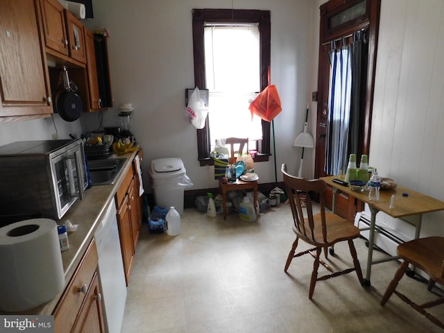 kitchen with white dishwasher, a healthy amount of sunlight, light tile floors, and baseboard heating