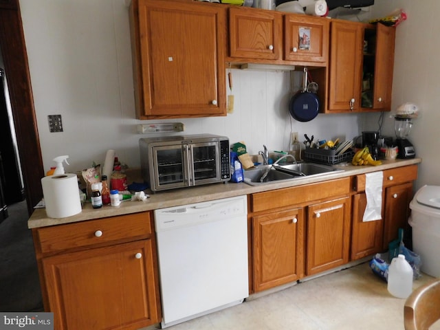 kitchen with sink, white dishwasher, and light tile floors