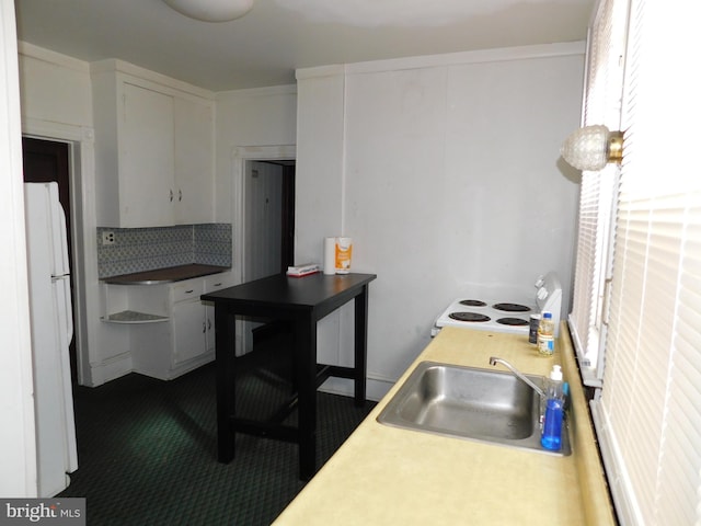 kitchen with white cabinets, range, white refrigerator, and sink