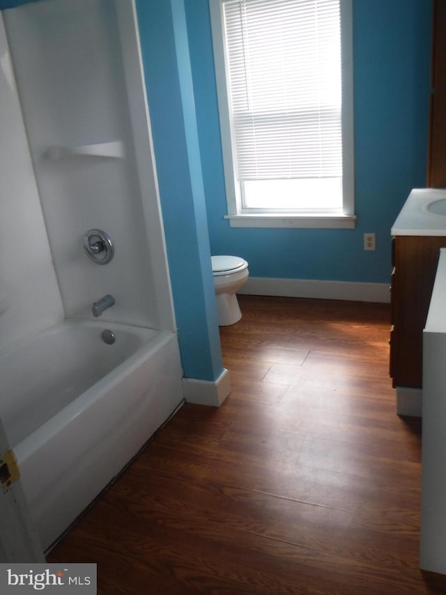 full bathroom featuring hardwood / wood-style flooring,  shower combination, toilet, and vanity