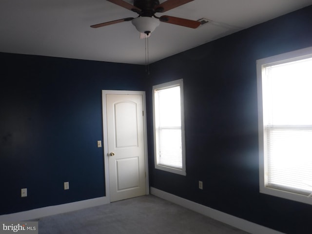 empty room featuring light colored carpet and ceiling fan