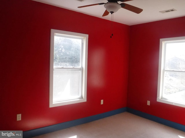 empty room with ceiling fan, carpet floors, and a healthy amount of sunlight