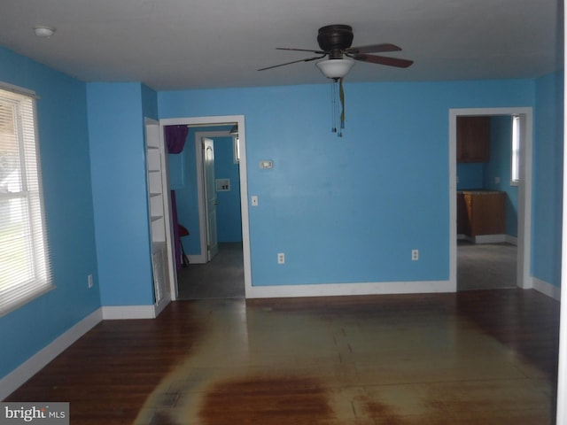 empty room with ceiling fan and dark hardwood / wood-style floors