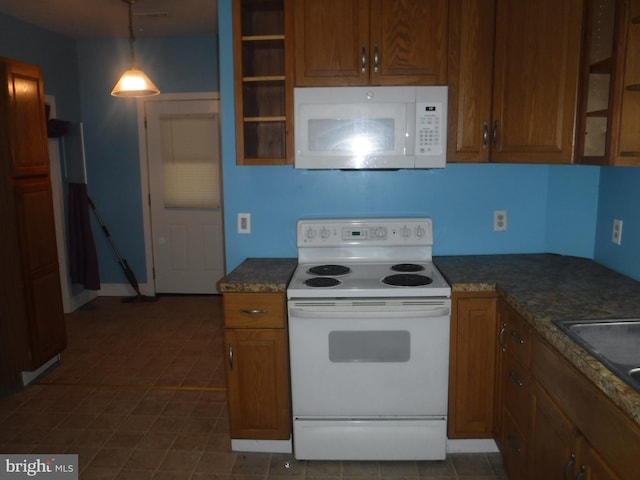 kitchen featuring white appliances, dark tile flooring, and pendant lighting