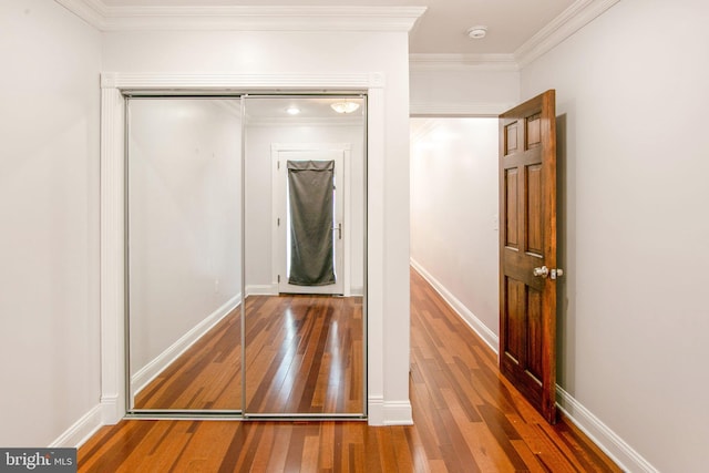 corridor with dark hardwood / wood-style flooring and ornamental molding