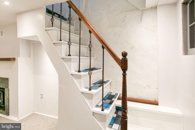 staircase featuring light carpet