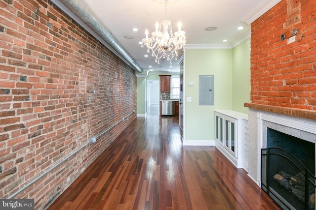 interior space with brick wall, dark wood-type flooring, crown molding, and an inviting chandelier