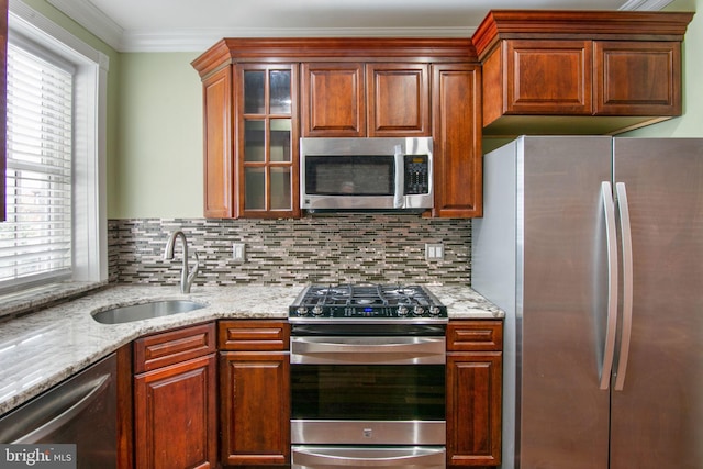 kitchen featuring light stone countertops, backsplash, stainless steel appliances, crown molding, and sink