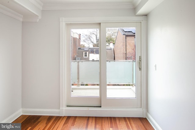 doorway with a healthy amount of sunlight, dark hardwood / wood-style flooring, and ornamental molding