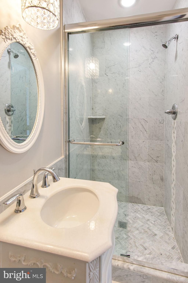 bathroom featuring oversized vanity and a shower with shower door