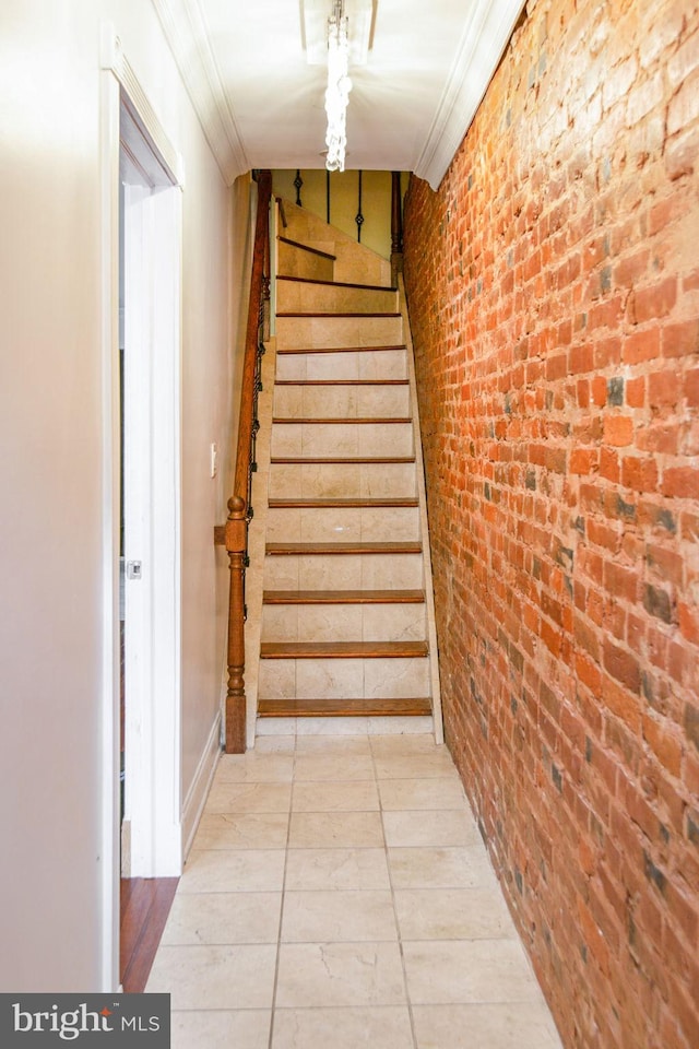 staircase with light tile flooring and brick wall