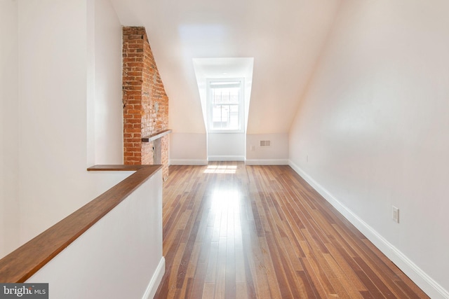 interior space featuring brick wall and hardwood / wood-style flooring