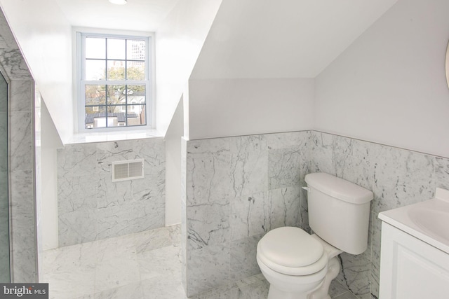 bathroom featuring vanity, tile walls, tile flooring, toilet, and lofted ceiling