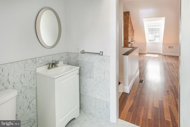 bathroom featuring toilet, vanity, and hardwood / wood-style floors