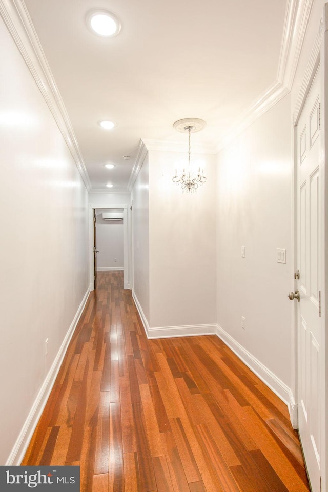 hall with ornamental molding, an inviting chandelier, and dark wood-type flooring