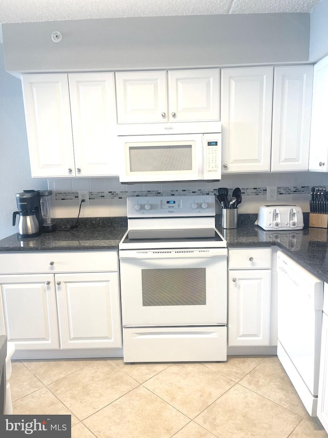 kitchen featuring white cabinets, decorative backsplash, light tile patterned floors, and white appliances