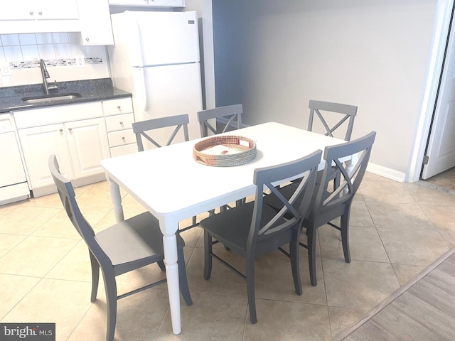 tiled dining room featuring sink