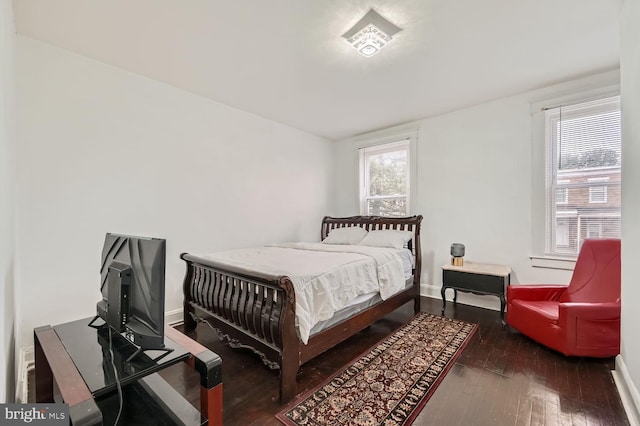 bedroom featuring dark wood-style floors and baseboards