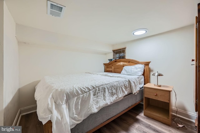 bedroom featuring visible vents, dark wood finished floors, and baseboards