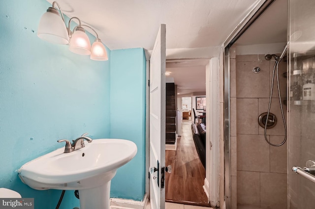 bathroom featuring a sink, wood finished floors, and a shower stall