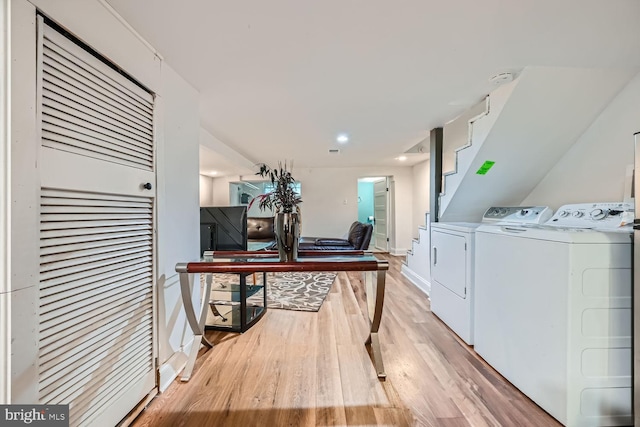 laundry area with laundry area, baseboards, washer and clothes dryer, and light wood finished floors