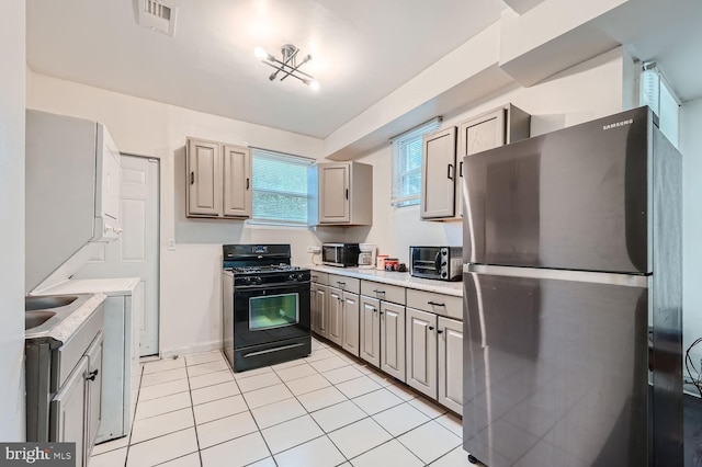 kitchen with a toaster, light countertops, visible vents, appliances with stainless steel finishes, and light tile patterned flooring