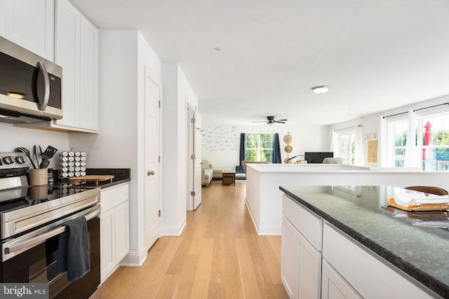 kitchen featuring light wood-type flooring, white cabinets, ceiling fan, and stainless steel appliances