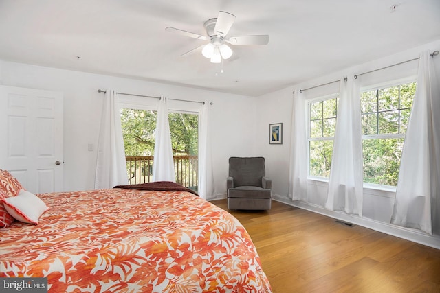 bedroom featuring access to exterior, light hardwood / wood-style floors, and ceiling fan