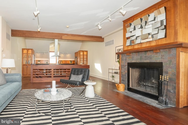 living room featuring wood-type flooring, a fireplace, beam ceiling, and rail lighting