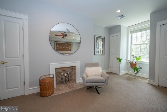 sitting room with ceiling fan and carpet