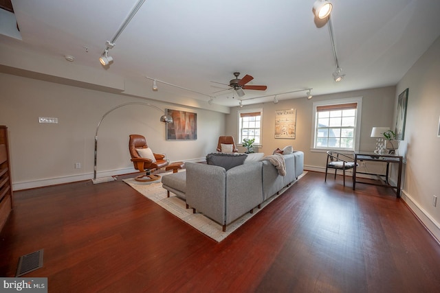 living room featuring rail lighting, ceiling fan, and dark wood-type flooring