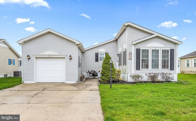 view of front of home featuring a front yard, central air condition unit, and a garage