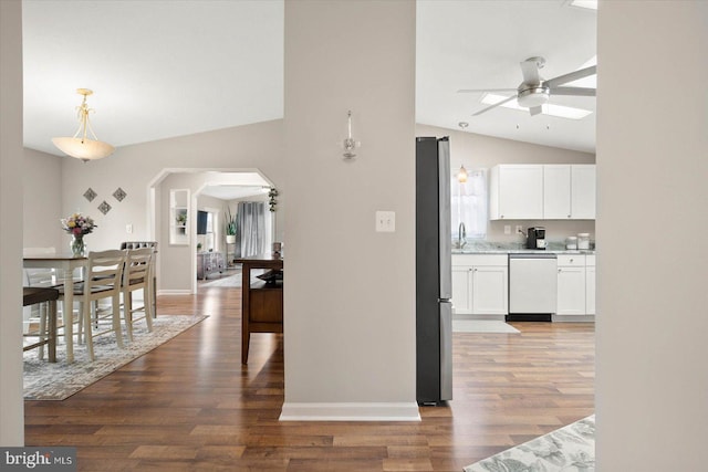 kitchen featuring hardwood / wood-style flooring, vaulted ceiling, stainless steel fridge, hanging light fixtures, and dishwasher