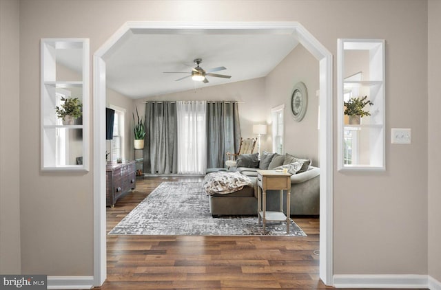 living room with ceiling fan, dark wood-type flooring, and lofted ceiling