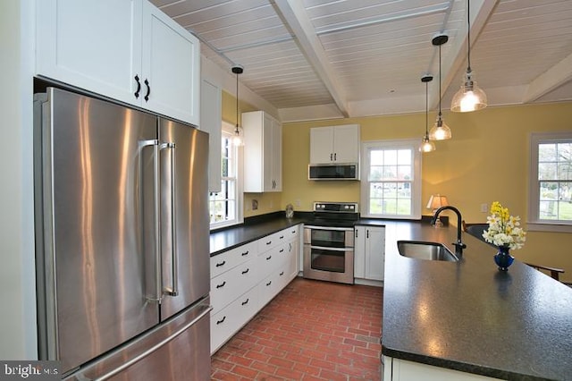 kitchen featuring white cabinets, stainless steel appliances, pendant lighting, and sink