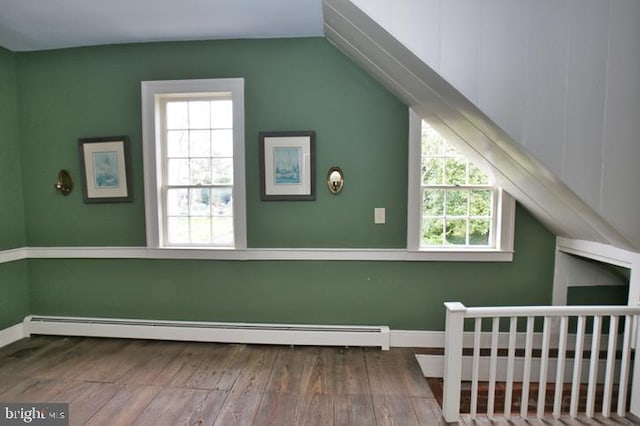 bonus room with wood-type flooring, baseboard heating, and vaulted ceiling