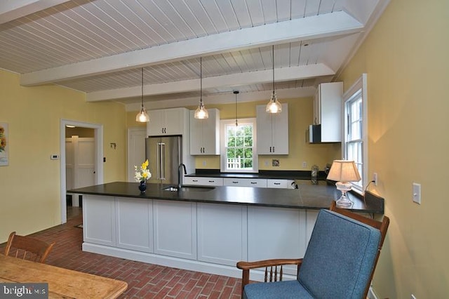 kitchen with beamed ceiling, hanging light fixtures, high end refrigerator, and white cabinetry