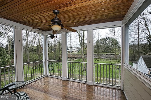 unfurnished sunroom with wooden ceiling, a healthy amount of sunlight, and ceiling fan