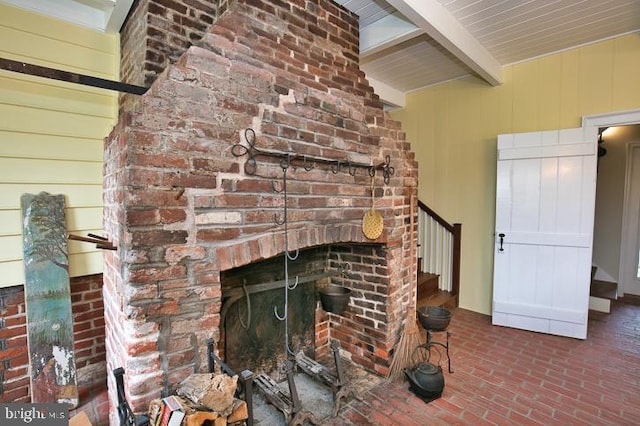 unfurnished living room with a fireplace and beam ceiling