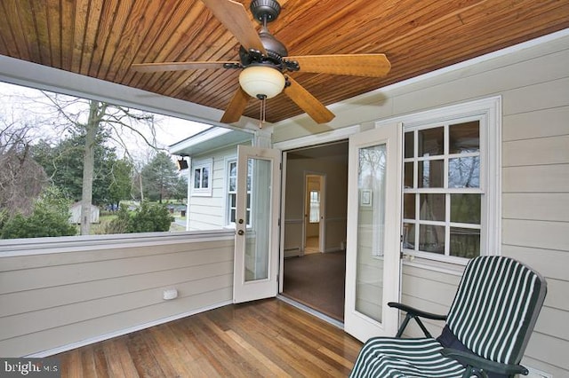 unfurnished sunroom with wood ceiling and ceiling fan