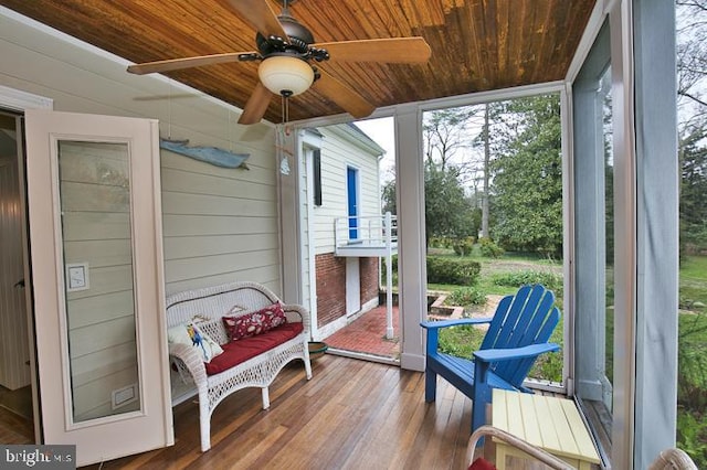 sunroom featuring wood ceiling and ceiling fan