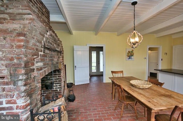 dining area with beamed ceiling and a chandelier