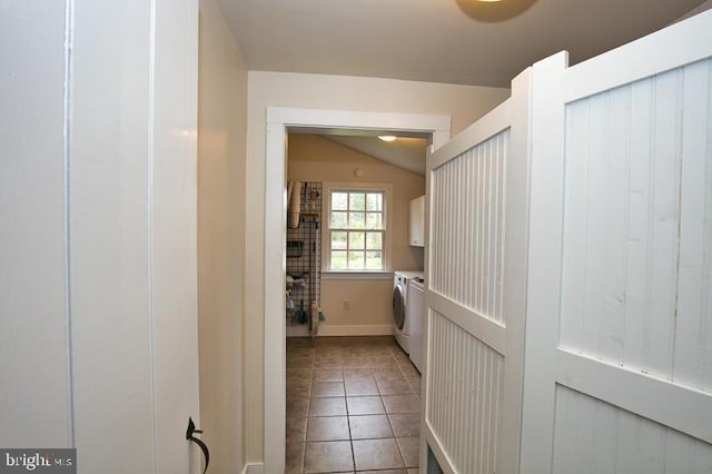 corridor featuring washing machine and clothes dryer, lofted ceiling, and tile patterned floors