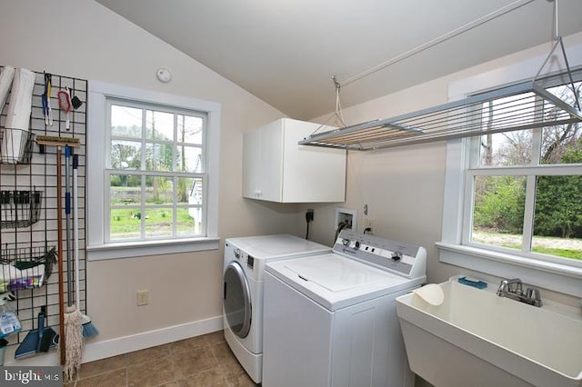 laundry area featuring cabinets, washing machine and clothes dryer, and sink