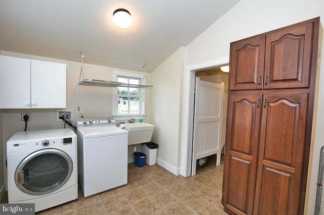 washroom featuring sink, independent washer and dryer, and cabinets