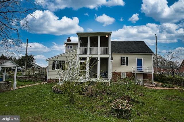 back of property featuring a sunroom and a yard