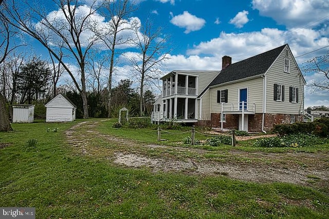 exterior space with a balcony, a shed, and a lawn